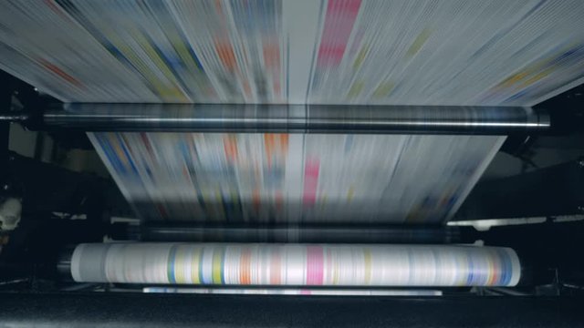 Rolling machine is relocating coloured printed paper