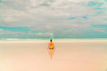 Yellow bikini Woman on beach. Tourist walking along Tropical Galapagos beach with turquoise ocean waves and white sand. Holiday, vacation, paradise, summer vibes. Isabela, San Cristobal