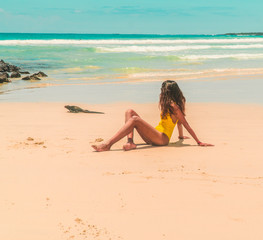 Woman, Iguana playing on beach Galapagos. Tourist on Tropical beach with turquoise ocean waves and white sand. Sand bay view. Holiday, vacation, paradise, summer vibes. Isabela, San Cristobal