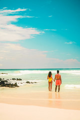 Fototapeta na wymiar Couple in beach holiday romance. Tourist on Tropical beach with turquoise ocean waves and white sand. Sand bay view. Holiday, vacation, paradise, summer vibes. Isabela, San Cristobal