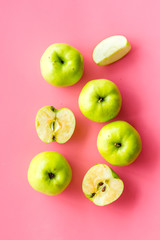 Autumn composition with green apple on pink background top view