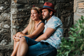 Young couple sitting on the stairs in an old village in Greece