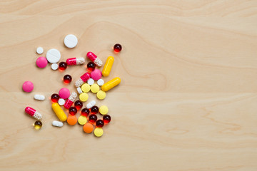 pills lies on a light wooden table
