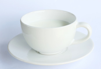 white ceramic mug with milk on white background