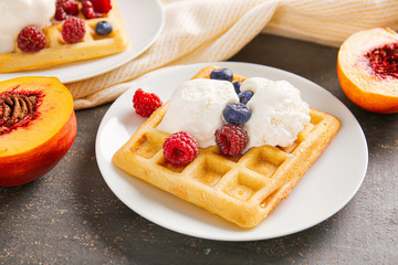 Tasty waffle with ice-cream and berries on plate
