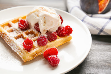 Tasty waffle with ice-cream and berries on plate, closeup