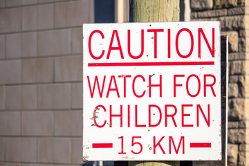 Caution: A sign warns to watch for children and sets a speed limit