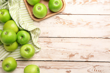 Fresh ripe apples on light wooden background