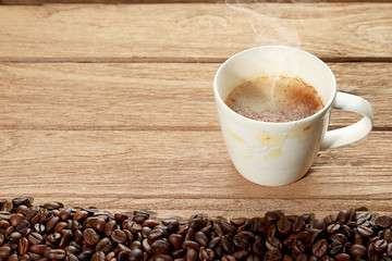 Latte Coffee in the white cup with smoke on the wooden table background. Foods and drink concept.