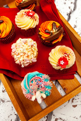 Mouth watering cupcakes on a wooden tray