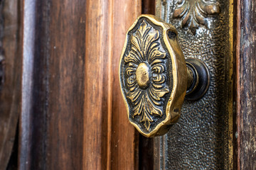 old metal doorknob on an ornate wooden door inside a church in Brazil