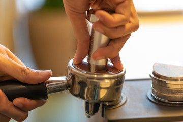Step by step coffee making part four. Tamping the ground coffee in the group handle or portafilter to ensure the right density for the extraction process