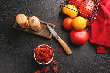 Composition with fresh and dried tomatoes on dark table