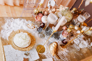 New Year mood. Table with a gold tablecloth, decorated with candles for celebration. Festive still...