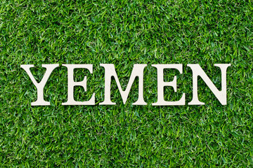 Wood alphabet letter in word Yemen on green grass background