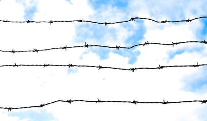Panoramic image with barbed wire and sky.