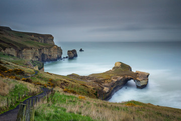 Cloudy day with moving cloud over the Tunnel beach at Otago Peninsula, New Zealand.