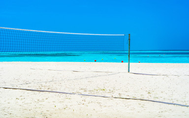 Volleyball net on a deserted sandy beach on the tropical sea.