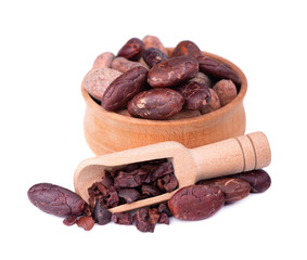 Peeled cocoa beans in the wooden bowl, isolated on white background. Roasted and aromatic cocoa beans in wooden spoon, natural chocolate.