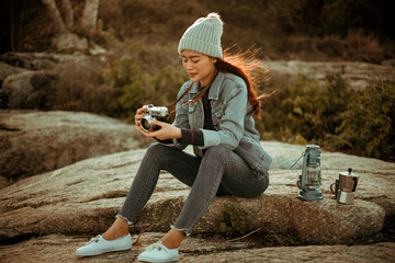 Asian woman drinking coffee on the mountain in sunset time camping travel concept