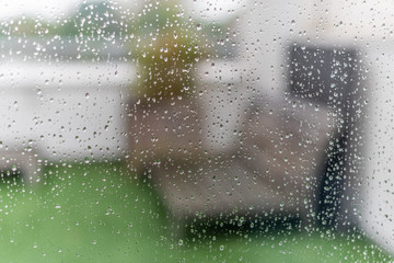 Water droplets on a window after the rain with a terrace in the background