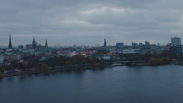4K Aerial Hamburg view of the city and buildings at dusk from Alster lake - Slow Motion