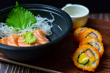 Salmon Sushi is a popular dish in Asia. Black bowl with chopsticks on the table, the concept of restaurant business.