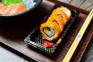 Salmon Sushi is a popular dish in Asia. Black bowl with chopsticks on the table, the concept of restaurant business.