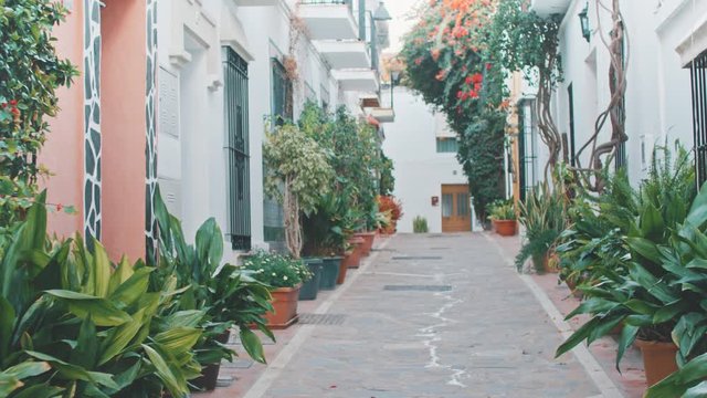 4K Marbella traditional old town street with greenery and white walls, Andalusia - Slow Motion
