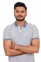Fototapeta premium Young handsome Indian man with arms crossed looking at camera