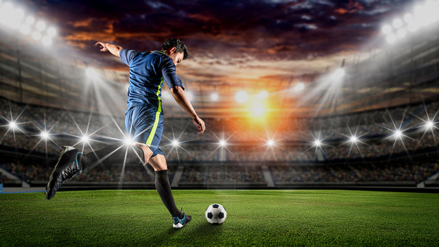 Soccer player kicks the ball on the soccer field.Professional soccer player in action.