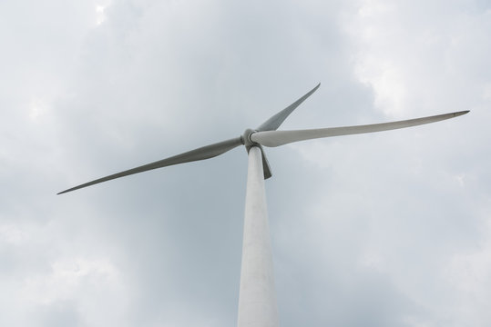 Close-up of a large wind turbine on a cloudy day background