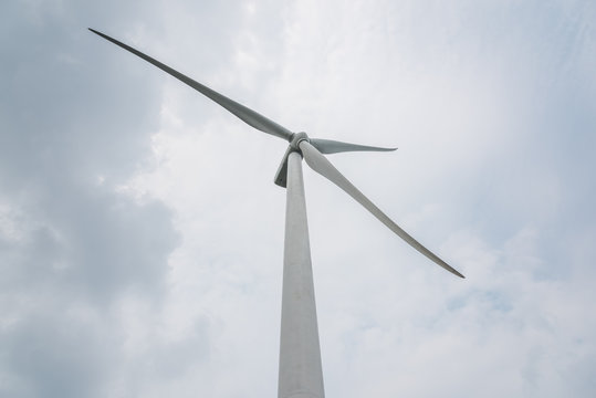 Close-up of a large wind turbine on a cloudy day background