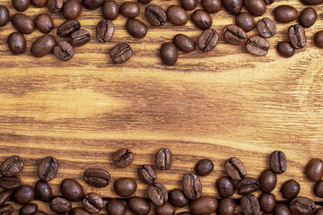 Coffee bean. The background of roasted coffee beans is brown on wooden boards. layout. Flat lay.
