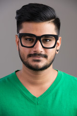 Fototapeta premium Face of young handsome Indian man wearing eyeglasses
