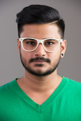 Obraz premium Face of young handsome Indian man wearing eyeglasses