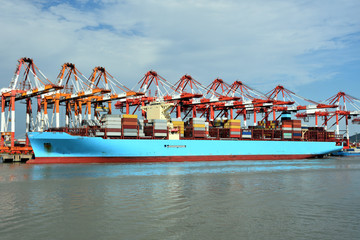 Fototapeta na wymiar Large cargo container ship in the port of Yangshan. Gantry cranes during cargo operations, loading and unloading containers. 
