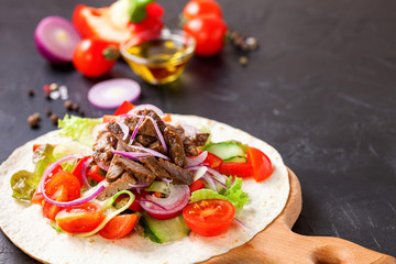 Tacos with Vegetables and Meat against a dark Background. Selective Focus.