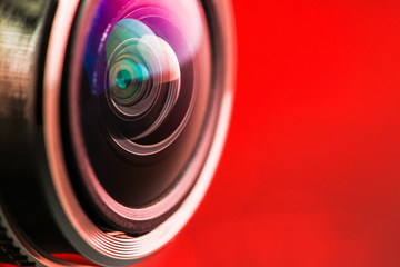Camera lens with red backlight. Side view of the lens of camera on red background. Camera Lens...