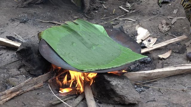 Cooking bread cakes on fire in the Ethiopian Dorsi tribe.