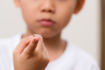 Little boy hold a contact lens