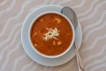 Red tomato soup with cheese , close up