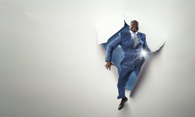 Breakthrough paper hole with a black businessman