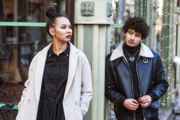 Young stylish couple on city street . A beautiful girl and a man in cool weather wear outerwear .