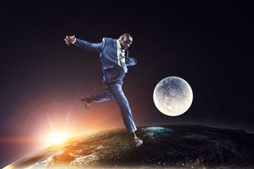 Black businessman plays soccer in space