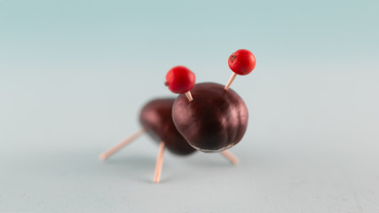 Creative natural children toys handmade from chestnuts and acorns on marine blue background. Concept of Chestnuts animal figurines.