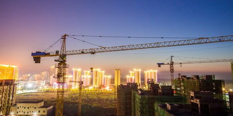 Tower cranes build residential buildings at nigh