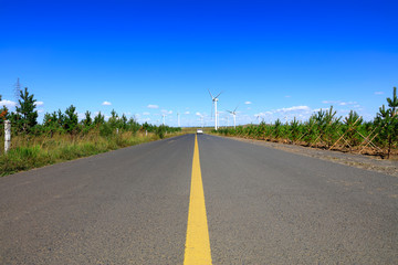 Asphalt road and wind turbines
