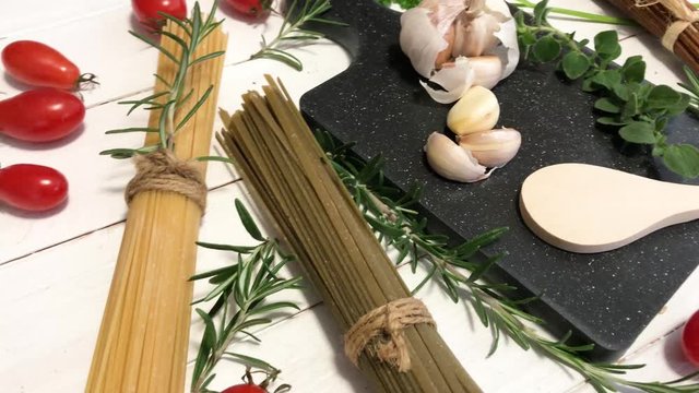 Ingredients for making pasta with garlic and tomatoes and herbs 