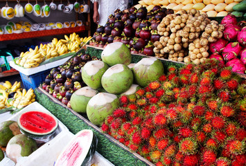 Fresh fruits on the shelves of a street vendor kiosk on a street in Thailand